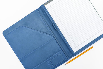 An open business notebook organiser with blue leather cover and a yellow pencil on white background, top view copy space