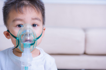 Closeup asian face little children boy using steam inhaler nebulizer mask inhalation