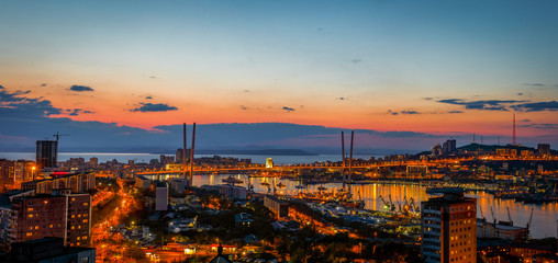 Fototapeta na wymiar Panorama of the city of Vladivostok. Panoramic view of the Golden Horn and the central part of Vladivostok from one of the hills of the city at sunset time.