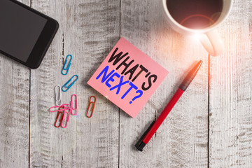 Conceptual hand writing showing What S Next Question. Concept meaning asking demonstrating about his coming actions or behaviors Stationary placed next to a coffee cup above wooden table