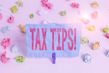 Conceptual hand writing showing Tax Tips. Concept meaning compulsory contribution to state revenue levied by government Colored crumpled paper empty reminder white floor clothespin
