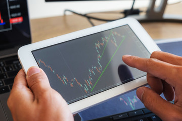 Trading on the table is working on a computer screen full of charts and data analysis and stock trading through online brokers