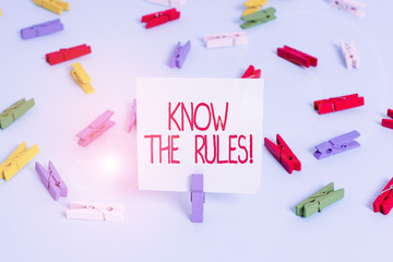 Writing note showing Know The Rules. Business concept for set explicit or regulation principles governing conduct Colored clothespin papers empty reminder blue floor officepin