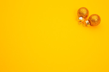 Copper Christmas baubles on orange background, with copyspace