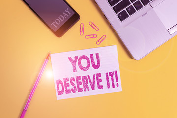 Word writing text You Deserve It. Business photo showcasing should have it because of their qualities or actions Trendy open laptop smartphone marker paper sheet clips colored background