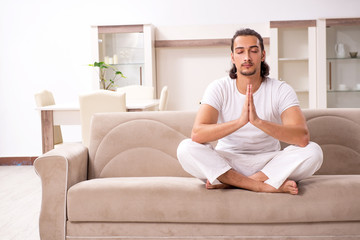 Young man doing physical exercises at home