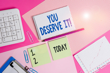 Conceptual hand writing showing You Deserve It. Concept meaning should have it because of their qualities or actions Writing equipments and computer stuffs placed on plain table