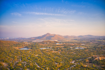 This unique photo shows the nature landscape with trees and hills from above with a unique cloudscape in the sunset in Hua Hin Thailand. The picture was taken with a drone.