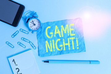 Text sign showing Game Night. Business photo text usually its called on adult play dates like poker with friends Alarm clock clips notepad smartphone sheet marker colored background