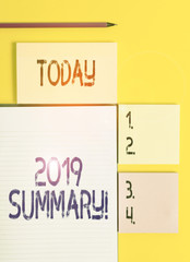 Handwriting text 2019 Summary. Conceptual photo summarizing past year events main actions or good shows Colored empty papers with copy space on the yellow background table