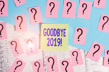 Conceptual hand writing showing Goodbye 2019. Concept meaning express good wishes when parting or at the end of last year Crumbling papers with thick cardboard on the wooden table