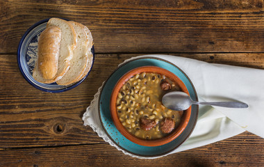 Still life of beans and bread on an old wooden background, dark food photography