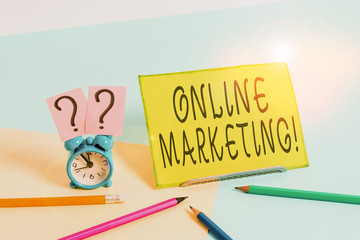 Conceptual hand writing showing Online Marketing. Concept meaning leveraging web based channels spread about companys brand Mini size alarm clock beside stationary on pastel backdrop