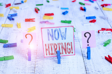 Writing note showing Now Hiring. Business concept for finding evaluating working relationship with future employees Crumbling sheet with paper clips placed on the wooden table
