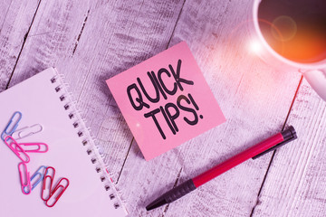 Writing note showing Quick Tips. Business concept for small but particularly useful piece of practical advice Stationary placed next to a cup of black coffee above the wooden table