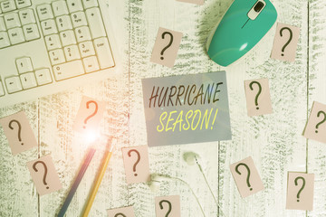 Word writing text Hurricane Season. Business photo showcasing time when most tropical cyclones are expected to develop Writing tools, computer stuff and scribbled paper on top of wooden table