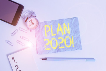 Text sign showing Plan 2020. Business photo text detailed proposal doing achieving something next year Alarm clock clips notepad smartphone sheet marker colored background