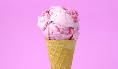 Strawberry ice cream scoop in waffle cone isolated on pink background, Closeup Front view Food concept.