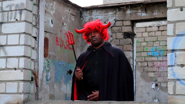 Devil rapper.  Funny afro america man  in fancy dress of devil is dancingand rapping. Carnival, dance, humor
