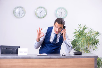 Young man receptionist at the hotel counter