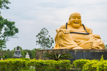 Foz do Iguacu, Brazil - Circa October 2019: Smiling Buddha and other two Buddha statues in the background at Chen Tien Buddhist Temple