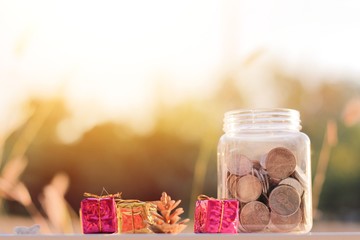  coins in piggy bank on wooden table with natural background, growing and savings money concept