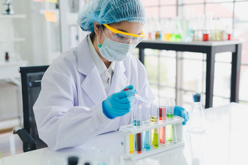 Fototapeta premium Asian scientists are testing and analyzing many chemicals in the lab. Science and Chemical Concepts.