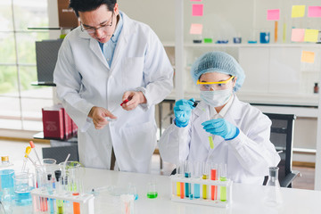 Asian scientists, men and women are helping to test and analyze various color chemicals in laboratories that have many scientific equipment.
