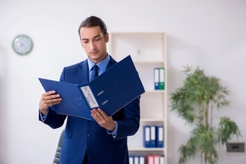 Young male accountant working in the office