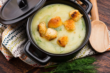 Creamy Jerusalem artichoke soup on wooden background