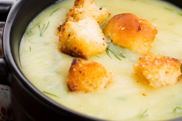 Creamy Jerusalem artichoke soup on wooden background