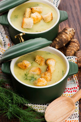 Creamy Jerusalem artichoke soup on wooden background