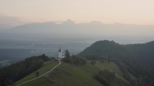 Sunrise over Jamnik, Slovenia. Aerial drone view over Alps and Church St. Primoz