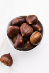 Bowl of chestnuts on a white background