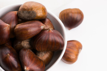Bowl of chestnuts on a white background