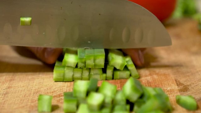 Latin woman cutting cilantro in the kitchen 