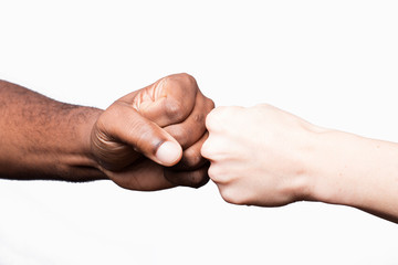 African man and Caucasian woman bumping fists, studio shot, isolated.