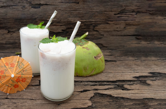 Coconut smoothie drink white fresh cocktail shake milkshake vanilla juice fruit beverage food healthy the taste yummy In glass on wooden background.