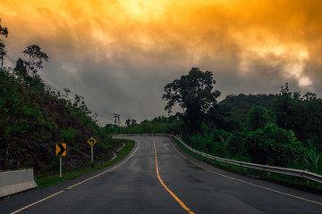 Blurred background of a mountain road view, from a car windscreen that runs with care, with natural scenery surrounded by plants, large trees