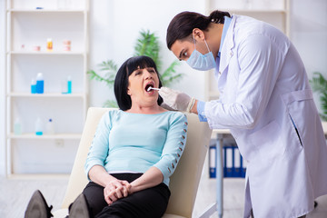 Obraz premium Old woman visiting young doctor dentist