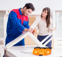 Contractor repairman assembling furniture under woman supervisio