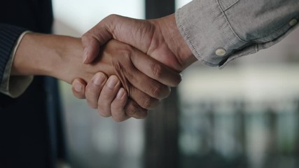Close up. Hand of two Asian business people gathered to handshake agree to a deal or say hello in the office