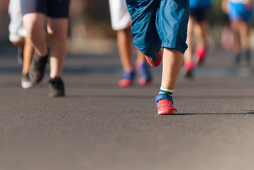 Fototapeta premium Running children, young athletes run in a kids run race,running on city road detail on legs