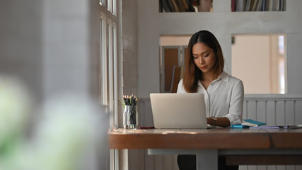 Businesswoman working her home office with laptop computer.