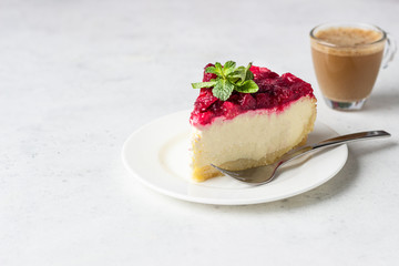 Classical New York cheesecake with cranberry sauce, mint and rosemary, light grey stone background. 