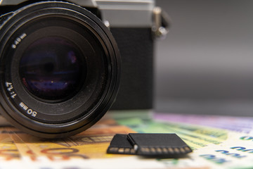Fototapeta na wymiar Alte Kamera mit Speicherkarten und Geldscheinen
