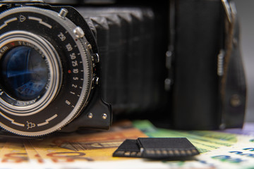 Fototapeta na wymiar Alte Kamera mit SD Karten und Geldscheinen von der Seite
