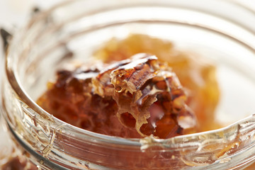 Honeycomb in glass jar on white background 