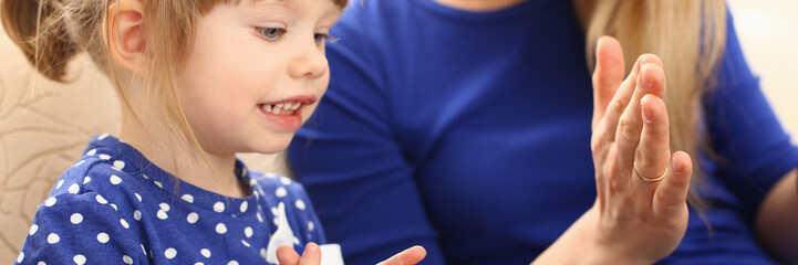 Cute little girl play with mom pat-a-cake