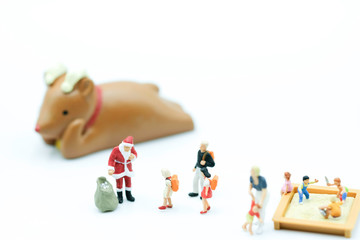 Miniature People : Santa in the red cloth with the bag in playground to distribute christmas gift to children use as happy new year concept.